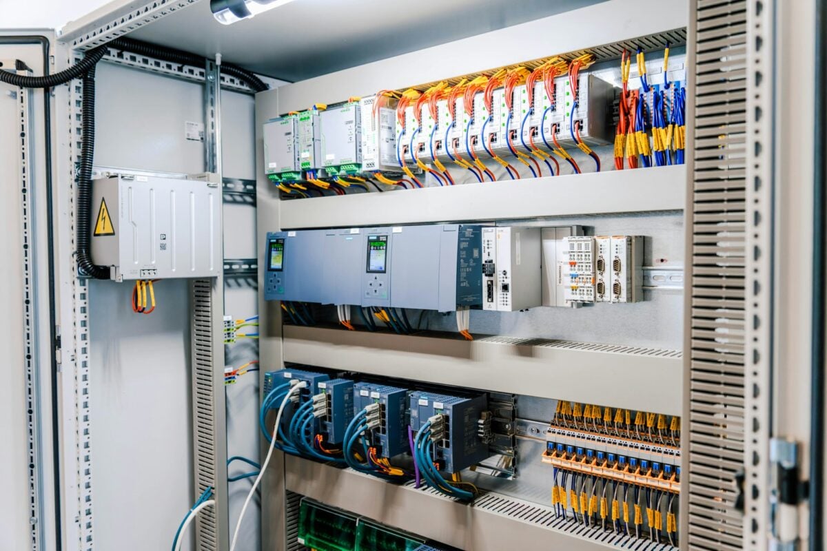 Open electrical control cabinet with PLC and wiring