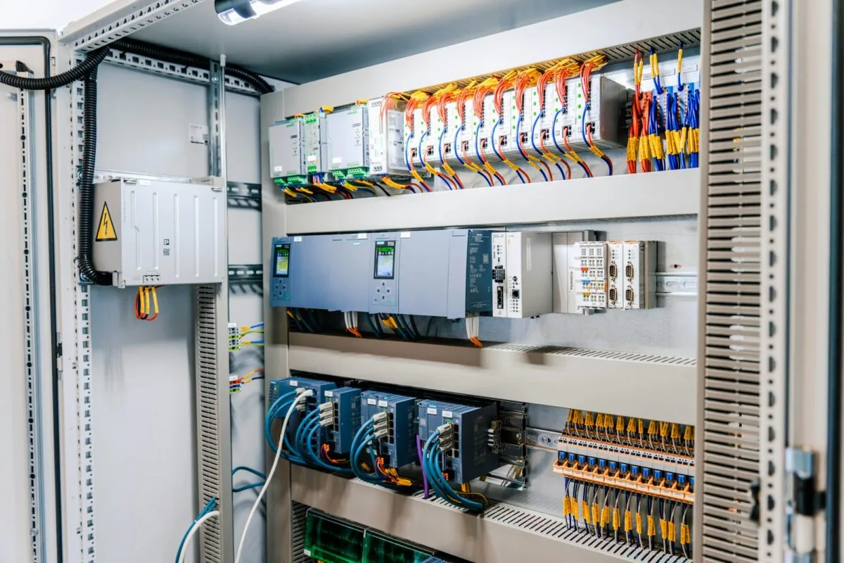 Open electrical control cabinet with PLC and wiring